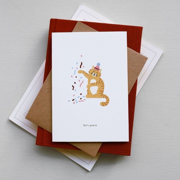 postal kartotek com um gato com a frase "let's pawty"