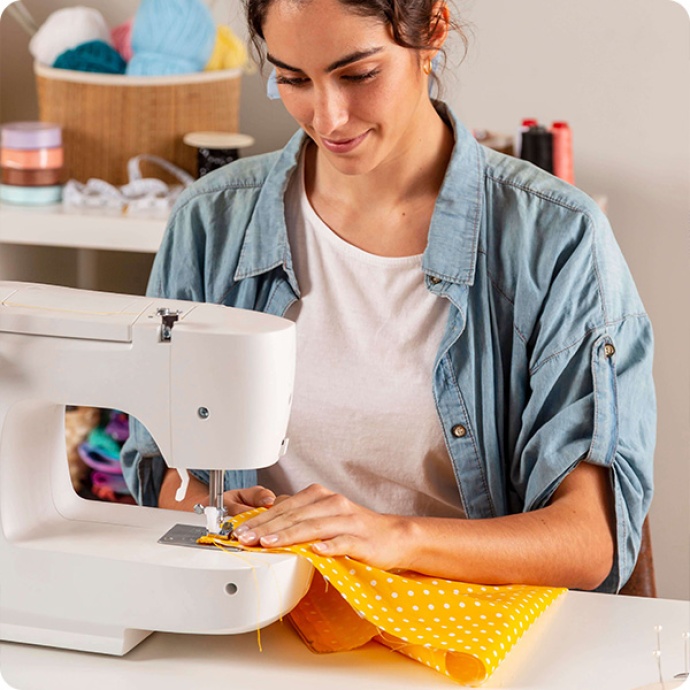 pessoa a costurar com máquina de costura