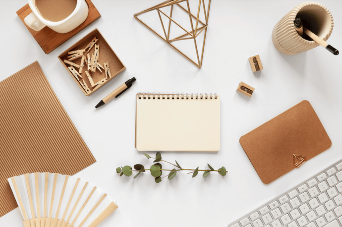 secretária com teclado, caderno, e material de escritório